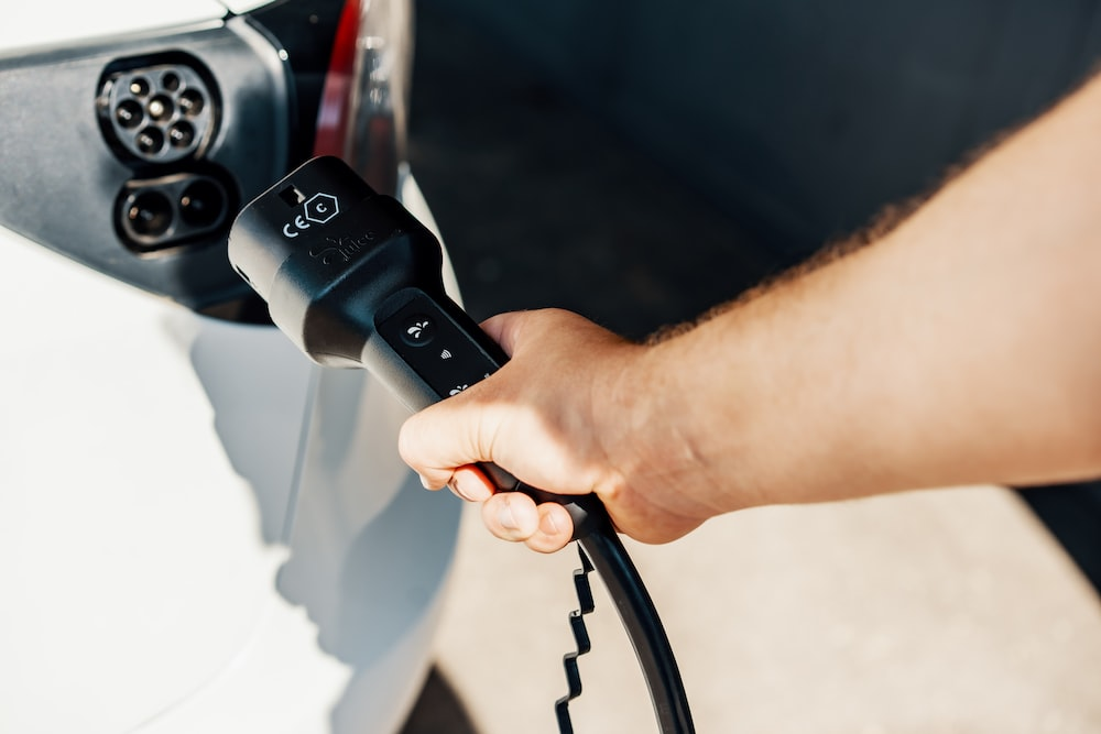 A person plugging electric car charger